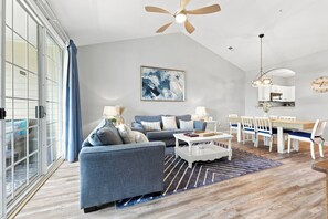 Ein modernes Wohnzimmer mit Sofa, Couchtisch und Essbereich.
