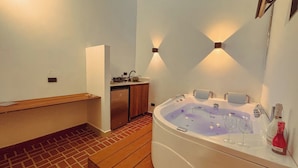 Un baño con un banco de madera, una bañera y un lavamanos.