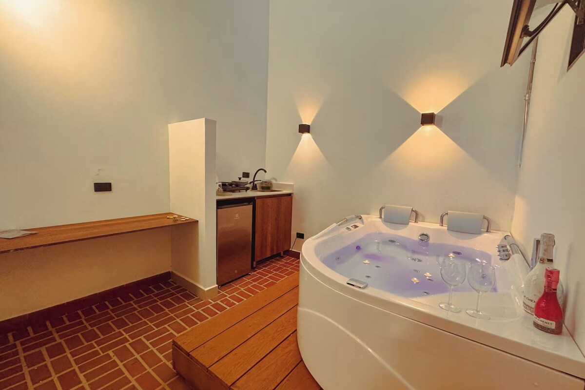 Un baño con un banco de madera, una bañera y un lavamanos.