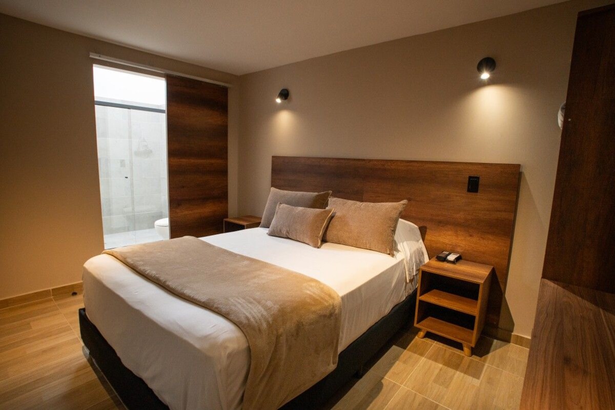 Una camera da letto moderna con un letto grande, comodini e vista sull'esterno.