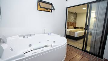 Une salle de bain moderne avec une baignoire sur pieds, une douche et des toilettes.