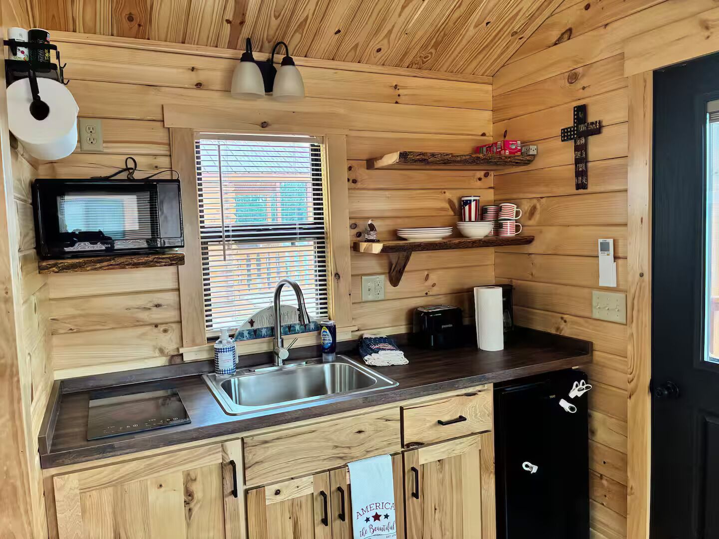 A compact kitchen with a sink, a microwave, and a refrigerator.