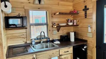 A compact kitchen with a sink, a microwave, and a refrigerator.