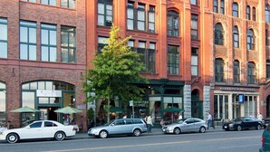 A historic building with a brick facade, large windows, and a bell tower. - Location, location location! (Seattle)