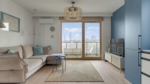 Un salon moderne avec un canapé, une table basse et un téléviseur.
