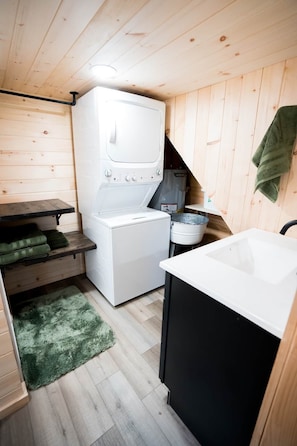 A compact kitchen with a white washing machine, a sink, and a small countertop. - Perfect Couples Retreat - firepit (Carlisle County)
