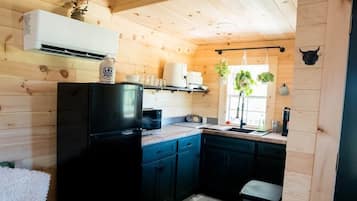 A wooden interior with a kitchen, a dining area, and a living room.