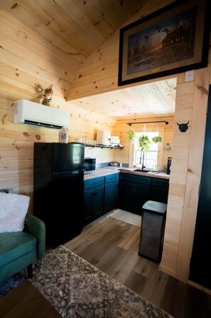 A wooden interior with a kitchen, a dining area, and a living room.
