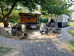 An outdoor patio area with a wooden pergola, a fire pit, and a grill station. - Perfect Couples Retreat - firepit (Carlisle County)