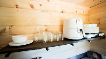 Un interno in legno con un bancone cucina che ospita una macchina da caffè, tazze e una ciotola.