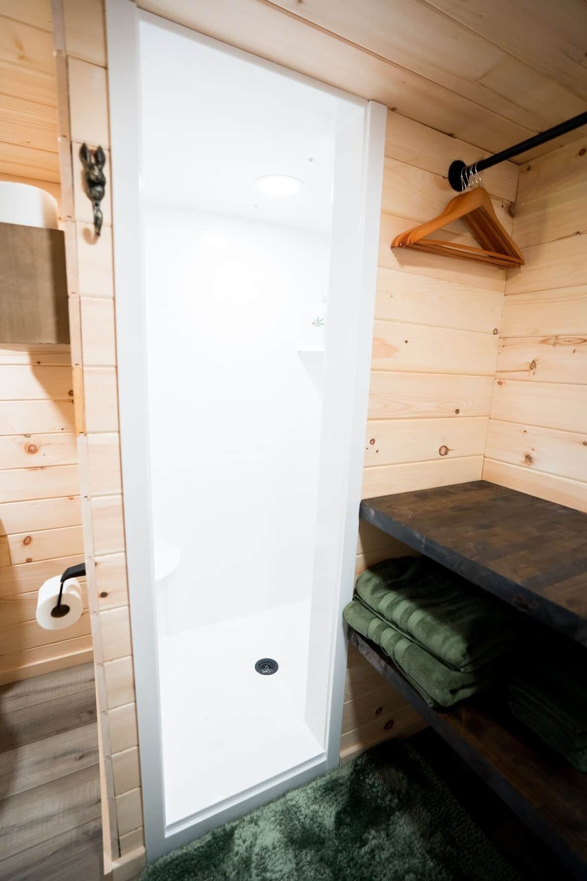 A narrow, white, vertical sliding door in a wooden cabin-style room.