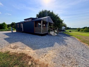 A two-story building with a porch and a staircase leading to the entrance. - The Roost | Hot Tub, Ponds & Farm Views (Carlisle County)