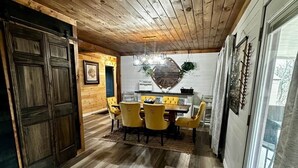 A dining area with a wooden ceiling, a dining table with chairs, and a rug with a geometric design. - Hot Tub + Pet Friendly / Perfect for travel ball (Paducah)