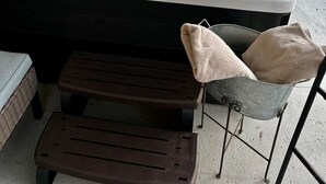 A hot tub with a wooden deck, a metal chair, and a small table. - Hot Tub + Pet Friendly / Perfect for travel ball (Paducah)