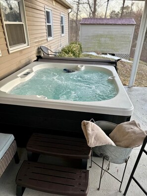 A hot tub with a wooden deck, a metal chair, and a small table. - Hot Tub + Pet Friendly / Perfect for travel ball (Paducah)