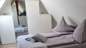 Un dormitori amb un llit, una catifes fosca i un armari.
