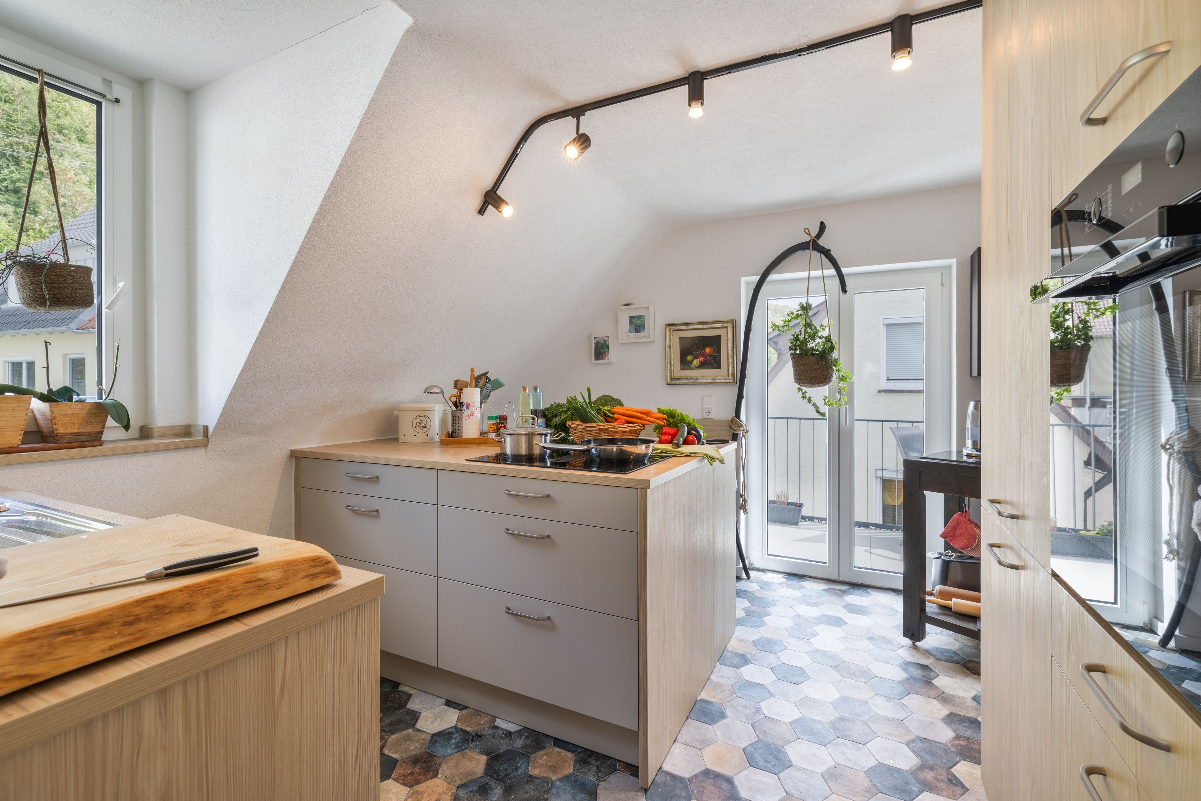 Une cuisine moderne dotée d’un îlot central, d’un coin repas et offrant une vue sur l’extérieur.