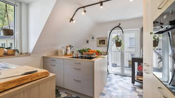 Uma cozinha moderna com ilha central, área de jantar e vista para o exterior.