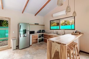 Eine moderne Küche mit integriertem Kühlschrank, einer Kaffeemaschine und einem großen Fenster.