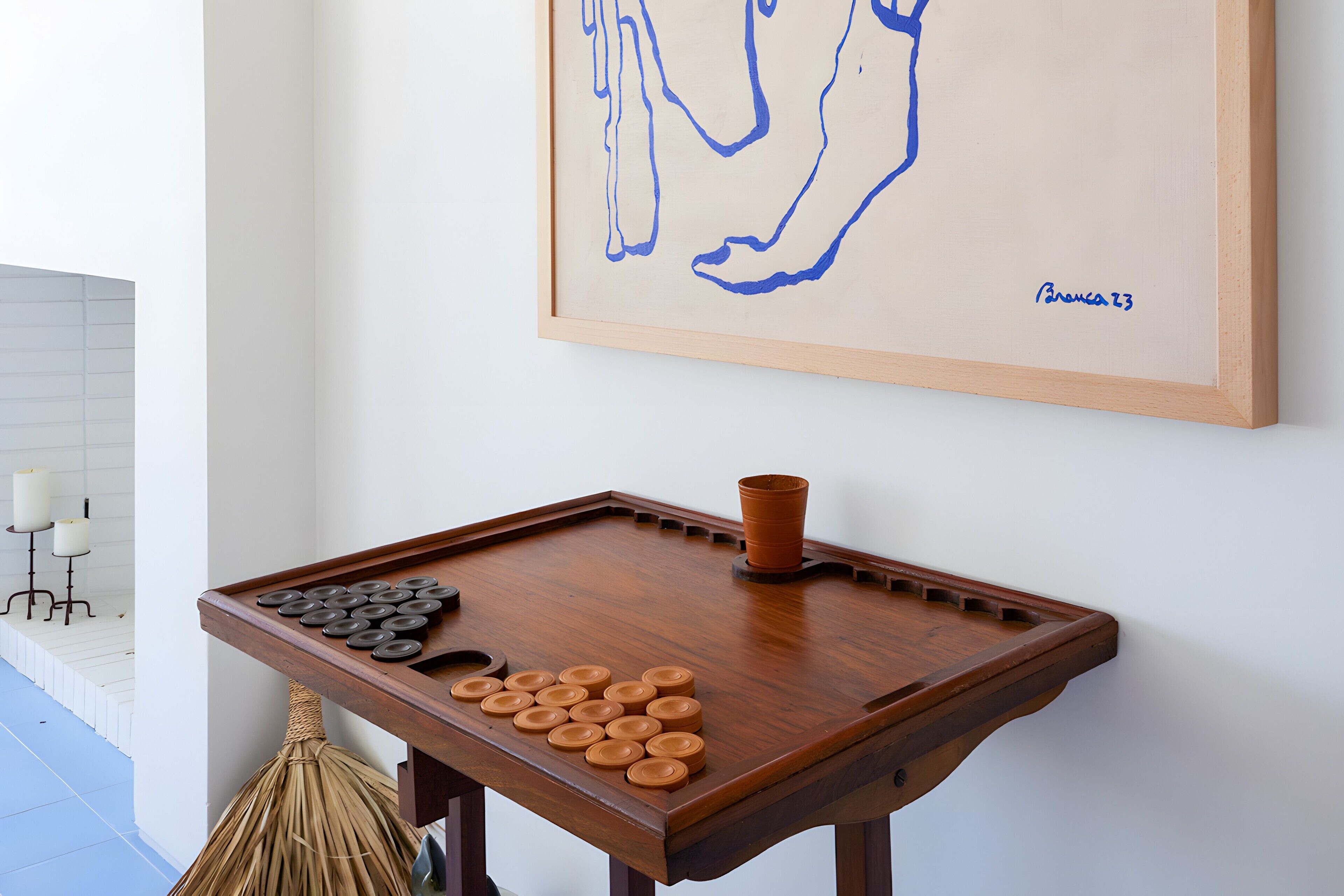 Ein Zimmer mit Holztisch, einem gerahmten Kunstwerk und einem dekorativen Gegenstand.