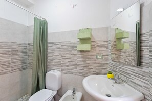 A bathroom with a toilet, sink, and shower curtain.