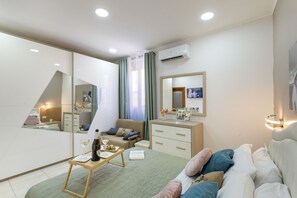 A modern bedroom with a bed, bedside table, dresser, and a large mirror. - Enjoy Casa – Your oasis between Mount Etna and the sea (Adrano)