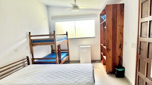 Habitació amb lliteres, escriptori, cadira, armari i finestra.