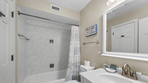 Un baño con bañera, inodoro y lavamanos.