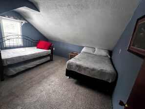 A bedroom with two beds, a window, and a sloped ceiling. - GORE MT RETREAT. Swimming pool, Hottub, TIKI BAR. FREE SKIPASSES!! (Johnsburg)