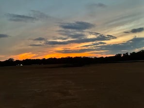 An open field with a sunset sky.