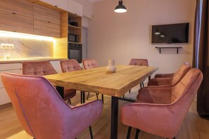 Comedor moderno con una mesa de madera y seis sillas rosas.