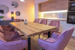 Een moderne eetruimte met een houten tafel en paarse stoelen met bekleding.