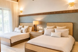 A hotel room with two beds, a nightstand, a lamp, and a view of the outdoors. - El Bosque II Casa de Campo (La Romana)