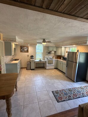 Una cocina compacta con una isla central, un refrigerador y una estufa.