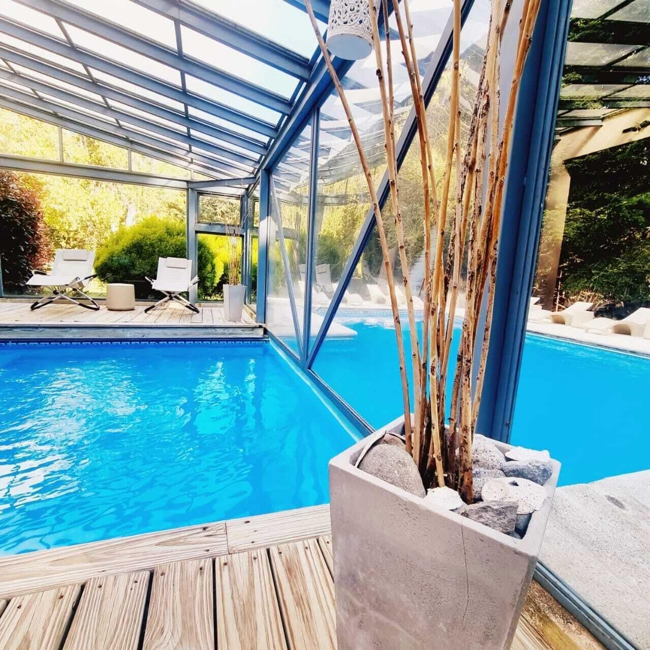 Una piscina cubierta, una piscina al aire libre, tumbonas