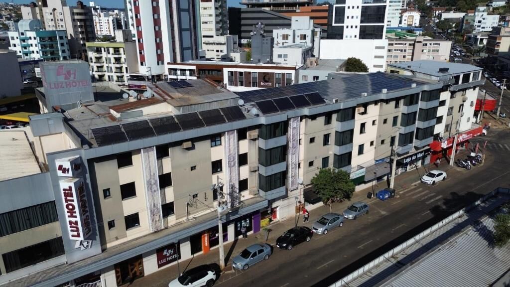 A multi-story hotel with a flat roof, solar panels, and a visible ground floor with a storefront.