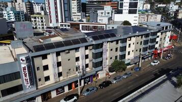 A multi-story hotel with a flat roof, solar panels, and a visible ground floor with a storefront.
