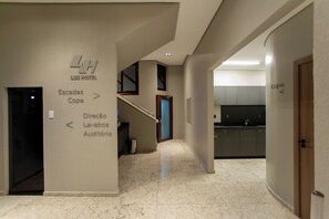 A hotel corridor with directional signs to the lobby, bathrooms, and an auditorium.