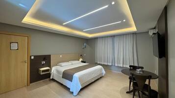 Una habitación de hotel con cama, mesita de noche, escritorio y silla.