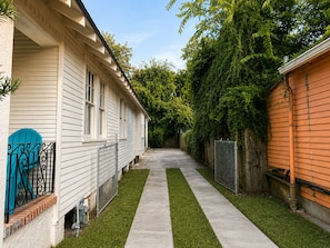 A residential property with a narrow pathway leading to a house with a blue door.