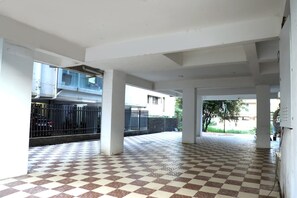 An open atrium with a checkered floor, columns, and a view of the outside. - Fantastic 3-bedroom apartment in Nashik perfect for your stay  and relaxation. (Nashik)