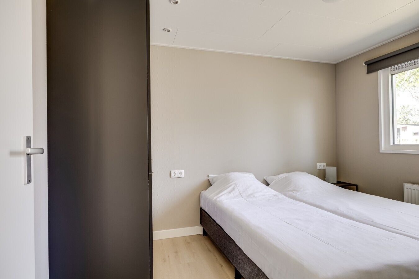 Une chambre à coucher avec un lit, une fenêtre et une porte.
