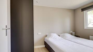 Une chambre à coucher avec un lit, une fenêtre et une porte.