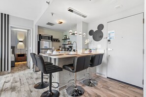 Een moderne keuken met een bar, roestvrijstalen apparatuur en een Mickey Mouse decoratie.