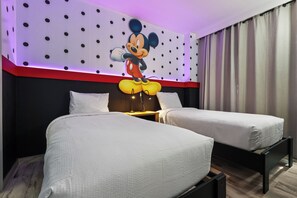 Een hotelkamer met twee bedden, een muurschildering van Mickey Mouse en een rode accentmuur.