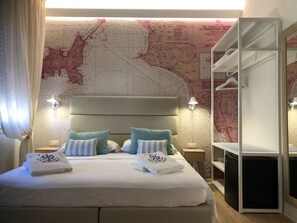 Una camera d'albergo con un letto grande, due comodini, un armadio e una mappa appesa al muro.