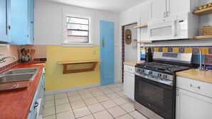 Une cuisine équipée d’une cuisinière, d’un four, d’un four à micro-ondes et d’une fenêtre.