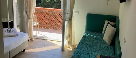 Una habitación con cama, escritorio y vistas al exterior.