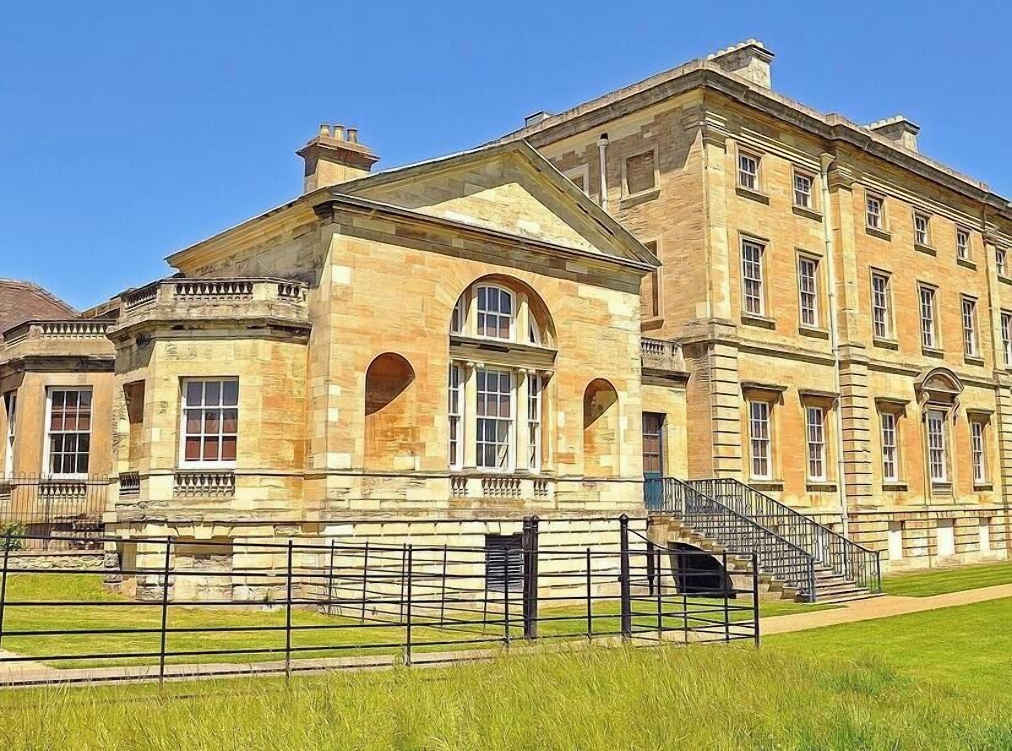 A large, historic building with multiple windows and a central entrance.