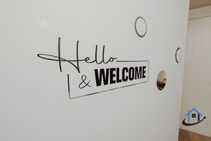 A wall with a 'Hello & Welcome' sign. - Apt 2 Manor House - 2 Bed 1 bath sleeps 5 parking (Desborough)